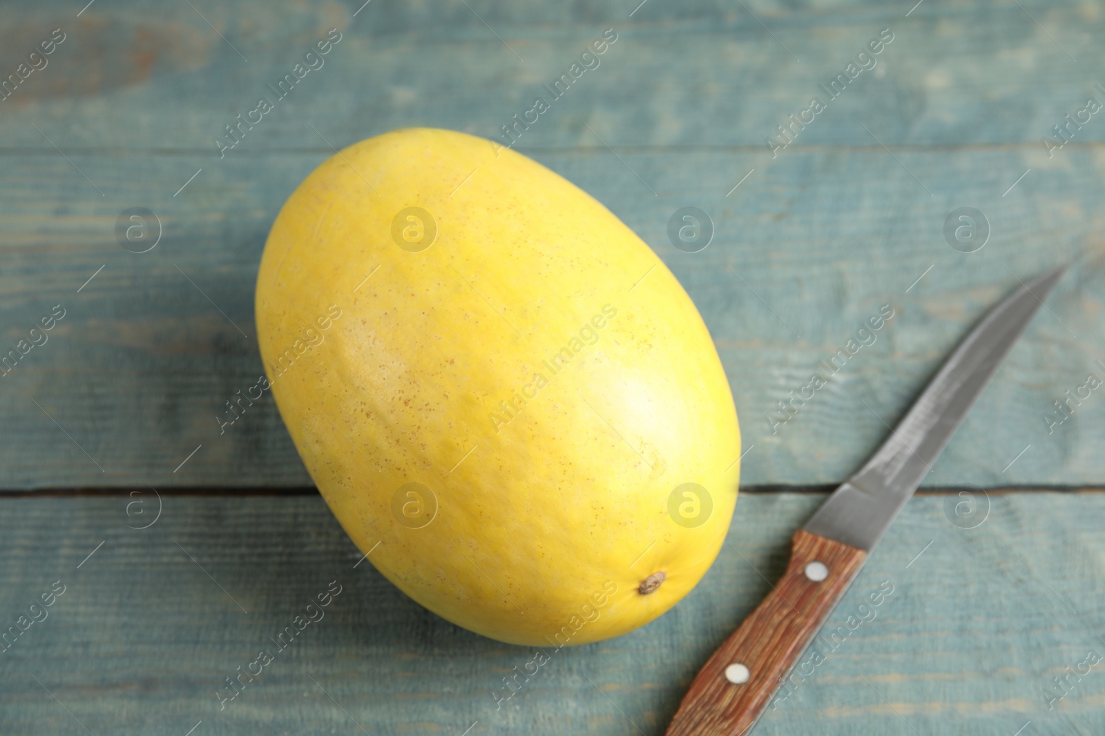 Photo of Ripe spaghetti squash and knife on wooden table