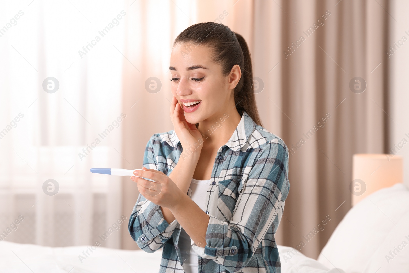 Photo of Young woman with pregnancy test at home. Gynecology and childbirth