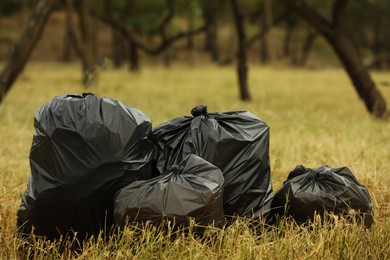 Photo of Trash bags full of garbage on grass outdoors