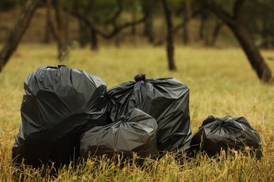 Trash bags full of garbage on grass outdoors