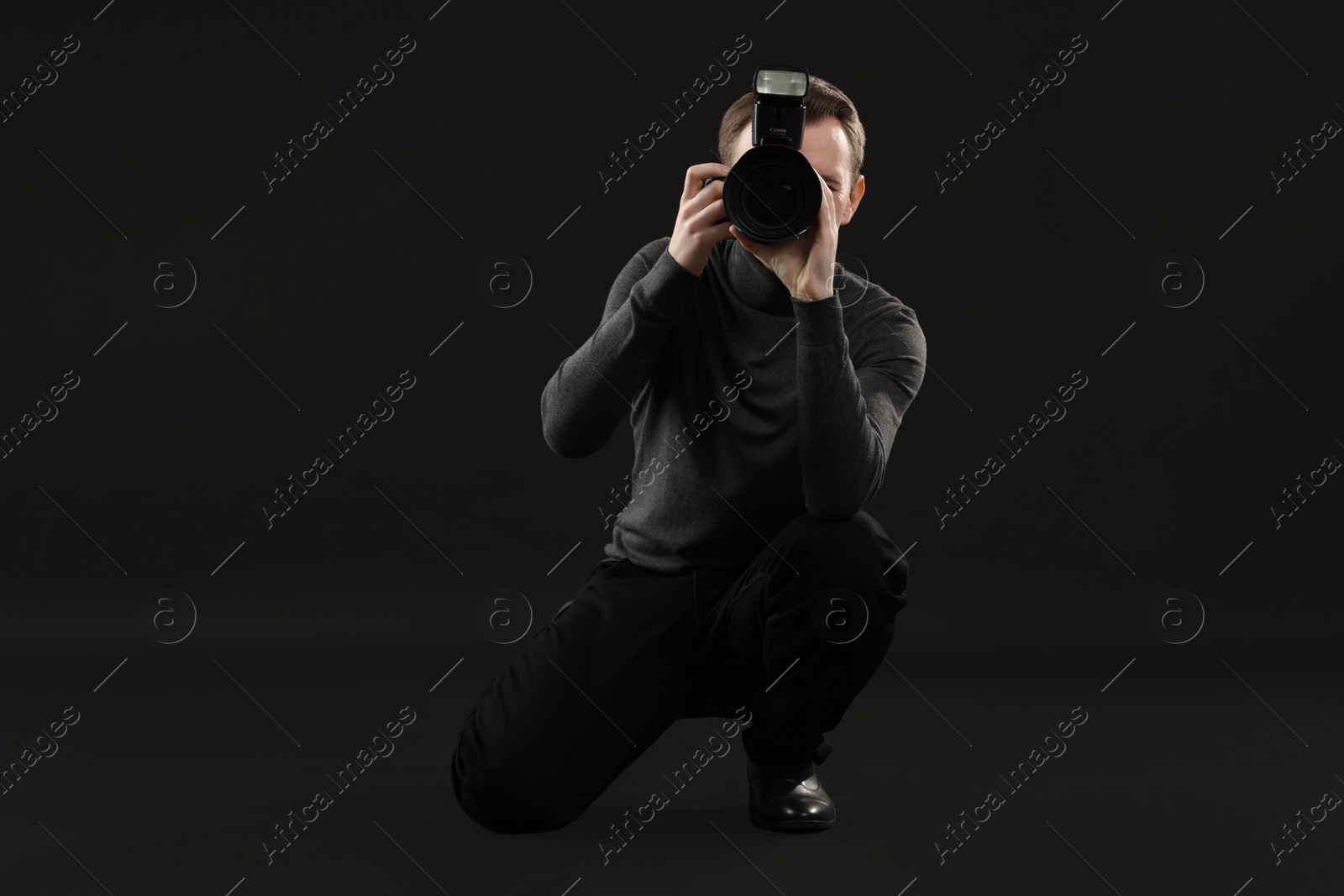 Photo of Professional photographer taking picture on black background