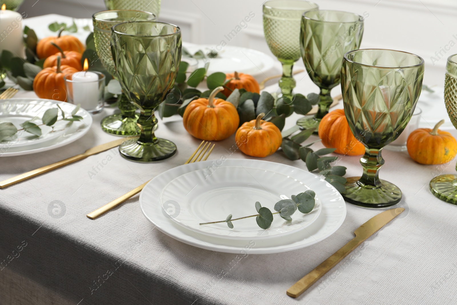 Photo of Beautiful autumn table setting. Plates, cutlery, glasses, pumpkins and floral decor