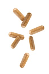 Vitamin. Many capsules falling on white background