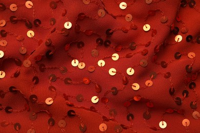 Photo of Beautiful red fabric with shiny sequins as background, top view