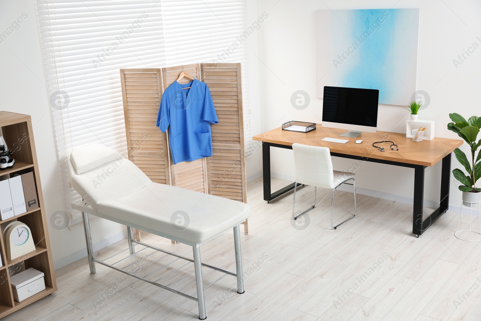 Photo of Modern medical office with doctor's workplace and examination table in clinic