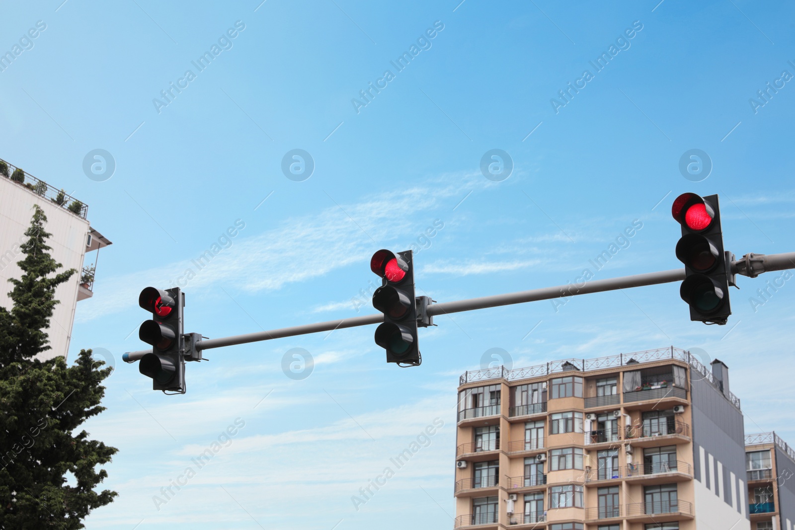 Photo of Modern traffic lights in city against cloudy sky