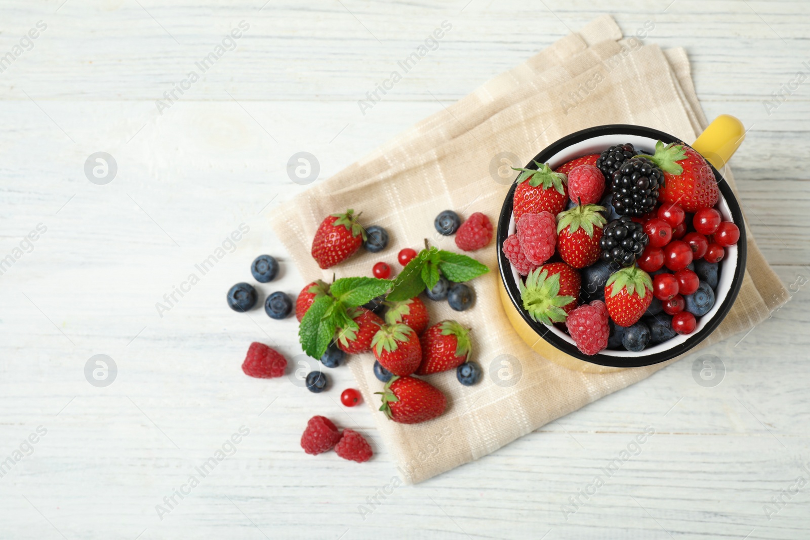 Photo of Mix of ripe berries on white wooden table, flat lay