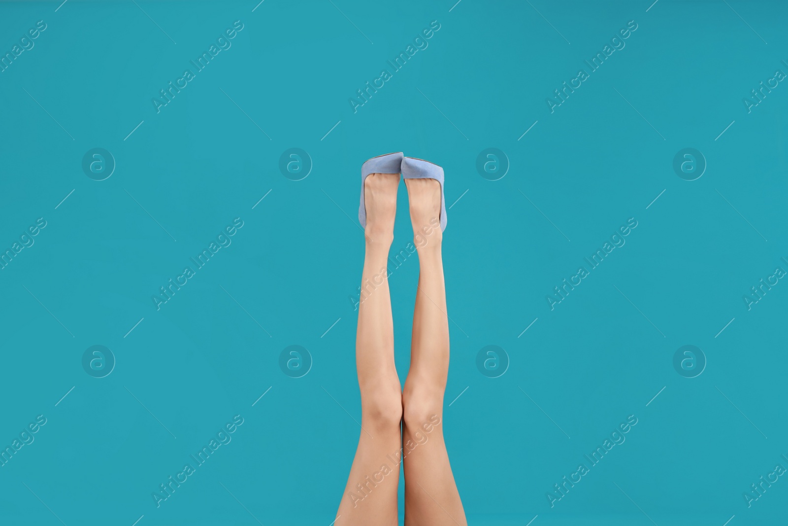 Photo of Woman in elegant shoes on light blue background