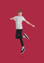 Image of Teenage boy jumping on red background, full length portrait