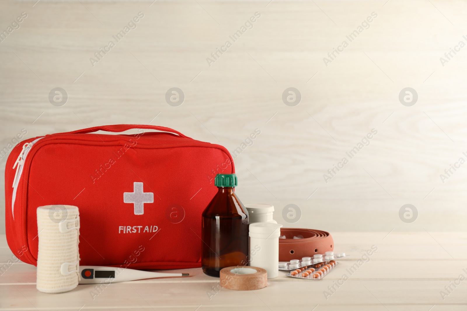 Photo of First aid kit on white wooden table, space for text