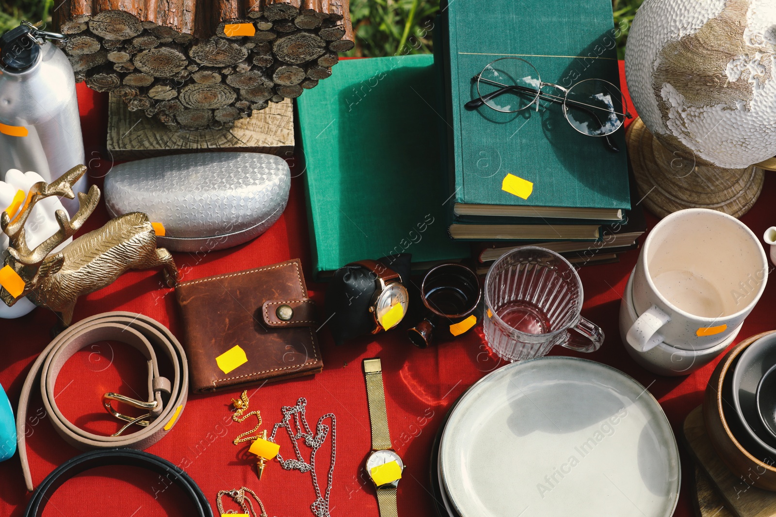 Photo of Many different items on table outdoors, above view. Garage sale