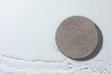 Photo of Presentation of product. Stone podium in water on white background, top view. Space for text