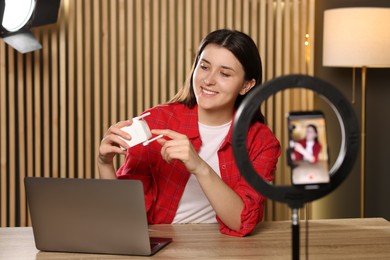 Photo of Smiling technology blogger recording video review about WI-FI extender at home