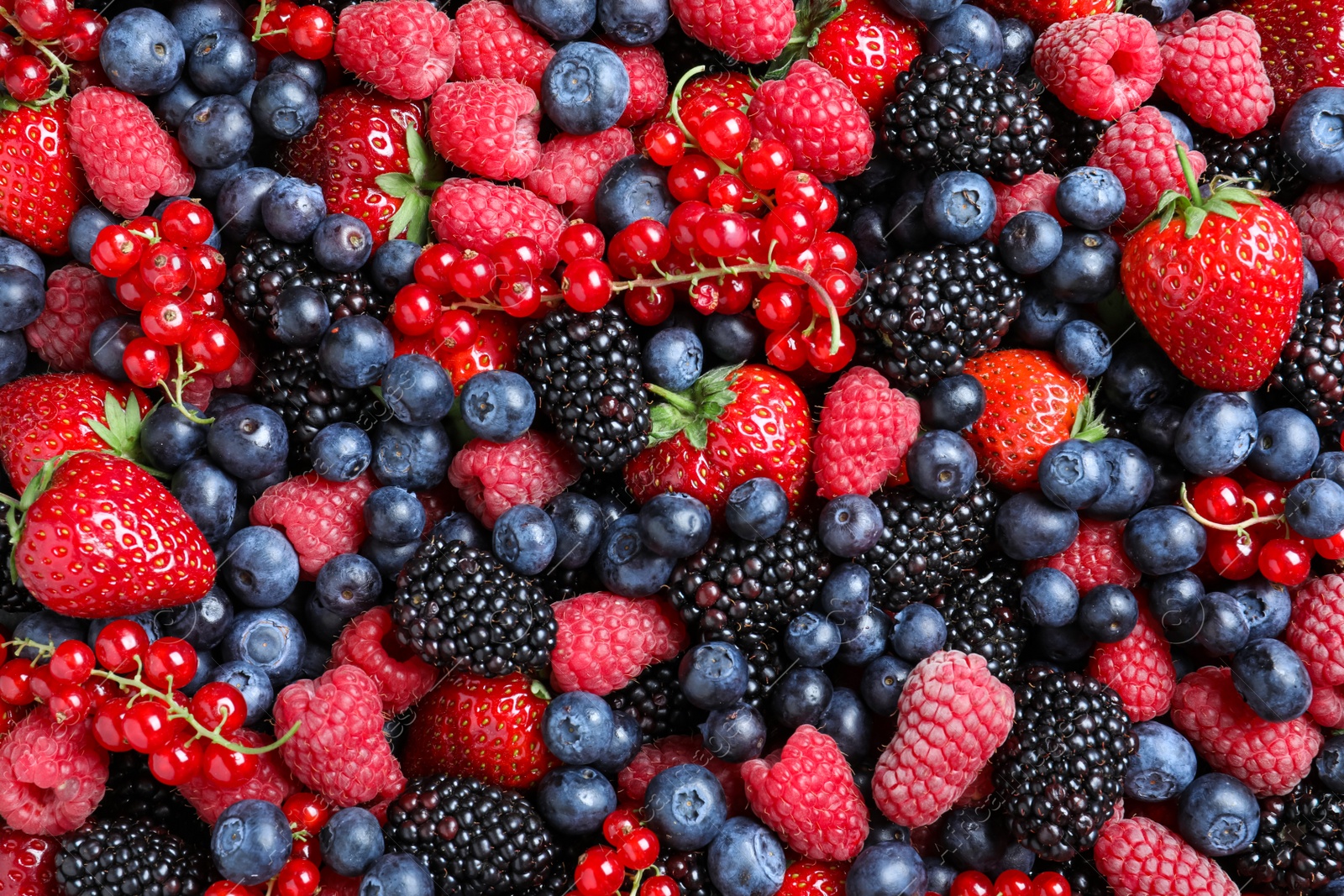 Photo of Mix of different ripe tasty berries as background, top view