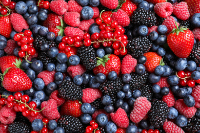 Photo of Mix of different ripe tasty berries as background, top view