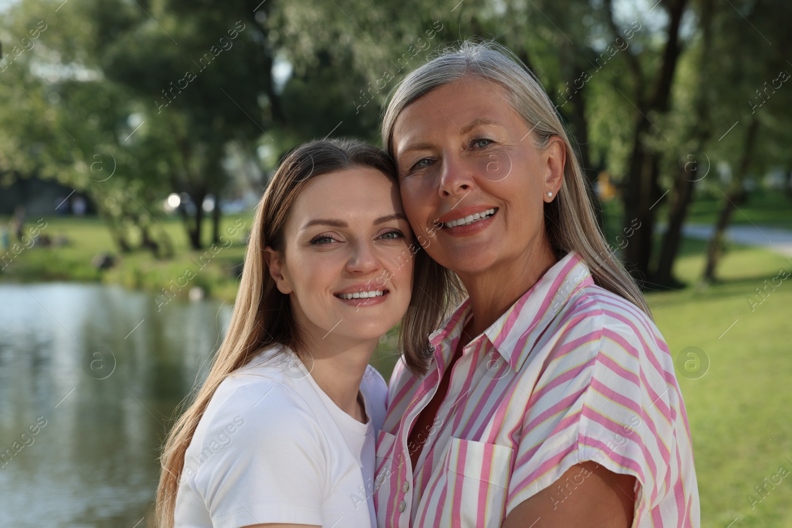 Photo of Family portrait of happy mother and daughter in park