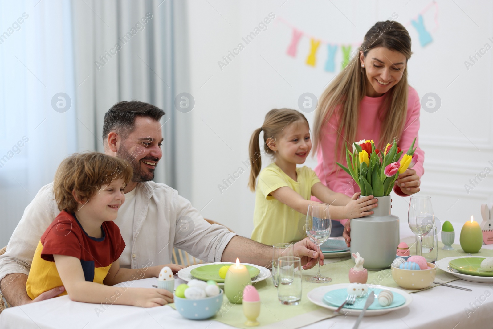 Photo of Easter celebration. Happy family setting table at home