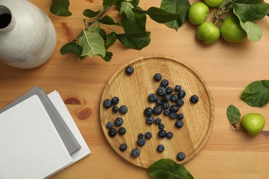 Flat lay composition with blueberries and green apples on wooden table