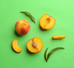 Flat lay composition with fresh peaches on green background