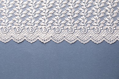 Photo of White lace on light blue background, top view. Space for text