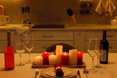Photo of Romantic atmosphere. Beautiful table with candles, bottles and tableware served for Valentine day