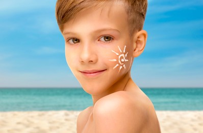 Image of Sun protection. Boy with sunblock on his face near sea, closeup