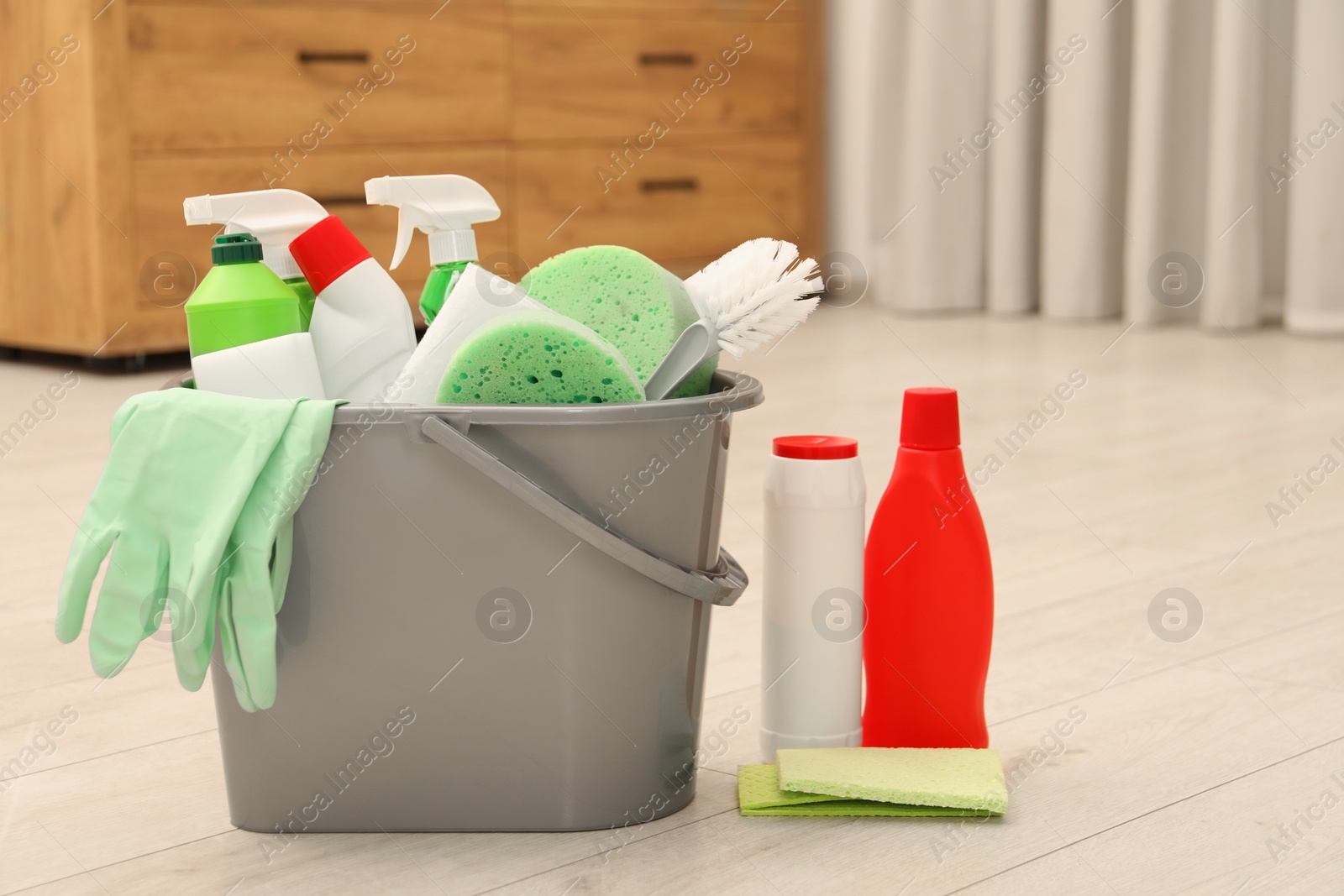 Photo of Different cleaning supplies in bucket on floor