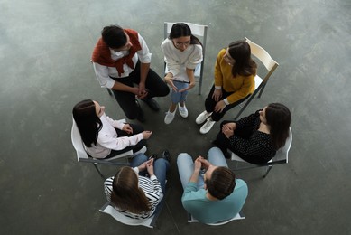Psychotherapist working with patients in group therapy session, top view