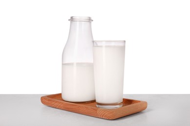 Glassware with tasty milk on light table against white background