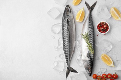 Photo of Raw mackerel, tomatoes and lemons on light gray table, flat lay. Space for text