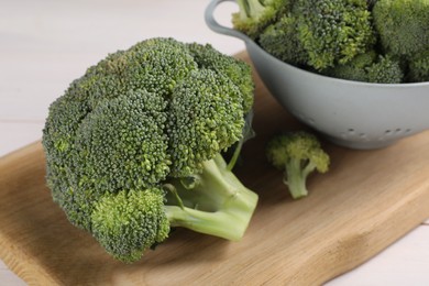 Photo of Fresh raw broccoli on white wooden table, closeup