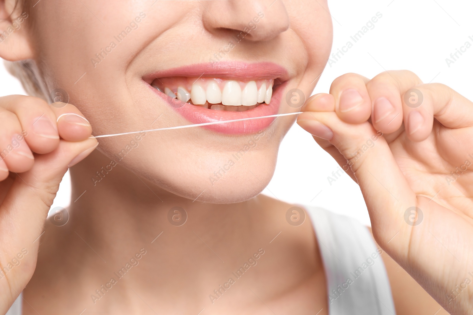 Photo of Young woman flossing her teeth on white background, closeup