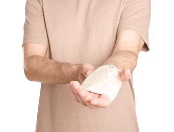 Photo of Man with hand wrapped in medical bandage on white background, closeup