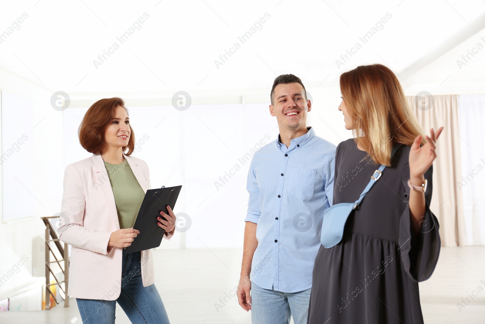 Photo of Real estate agent showing new apartment to young couple