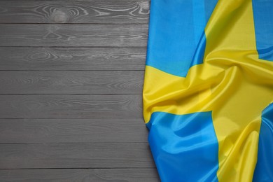 Flag of Sweden on gray wooden background, top view. Space for text