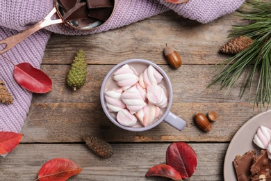 Flat lay composition with hot cozy drink and autumn leaves on wooden background