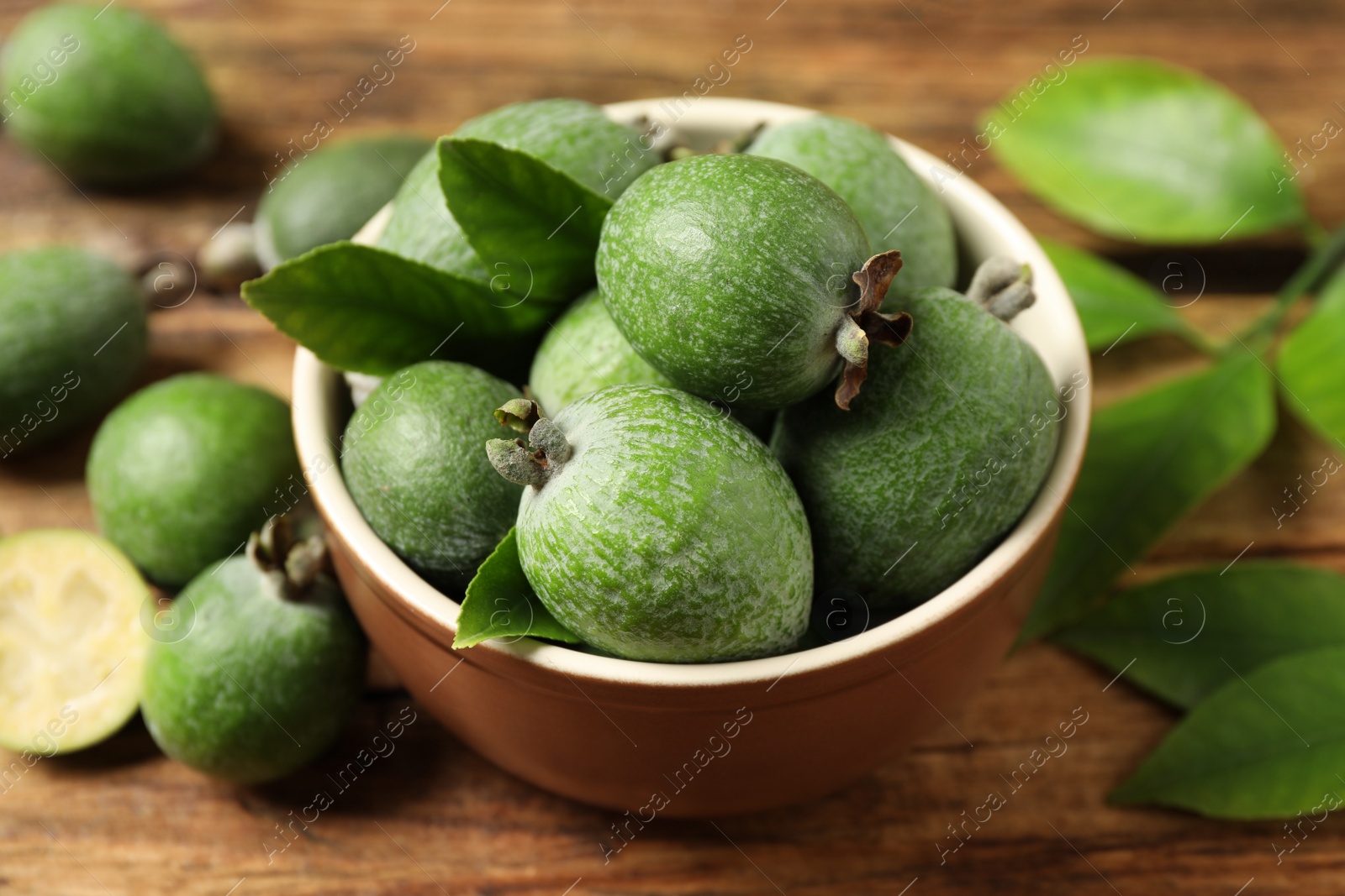 Photo of Fresh green feijoa fruits on wooden table, closeup