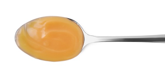 Spoon with tasty salted caramel isolated on white, top view