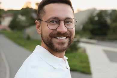 Photo of Portrait of handsome bearded man in glasses outdoors