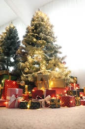 Many different gifts under Christmas tree indoors