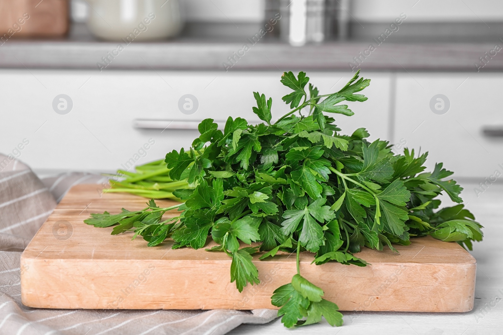 Photo of Wooden board with fresh green parsley on table