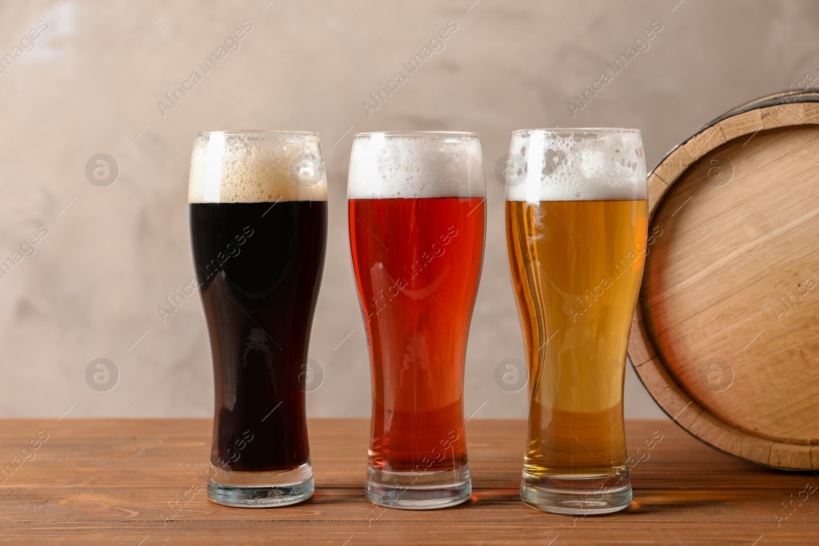 Photo of Glasses with different types of cold tasty beer on wooden table