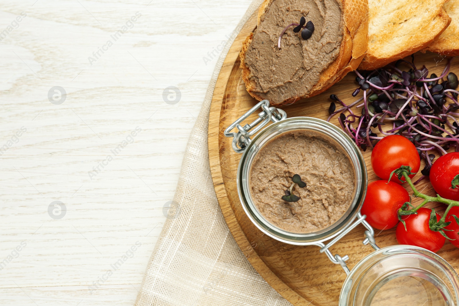 Photo of Delicious liver pate, bread and tomatoes on white wooden table, top view. Space for text