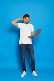 Photo of Pensive man with laptop on light blue background