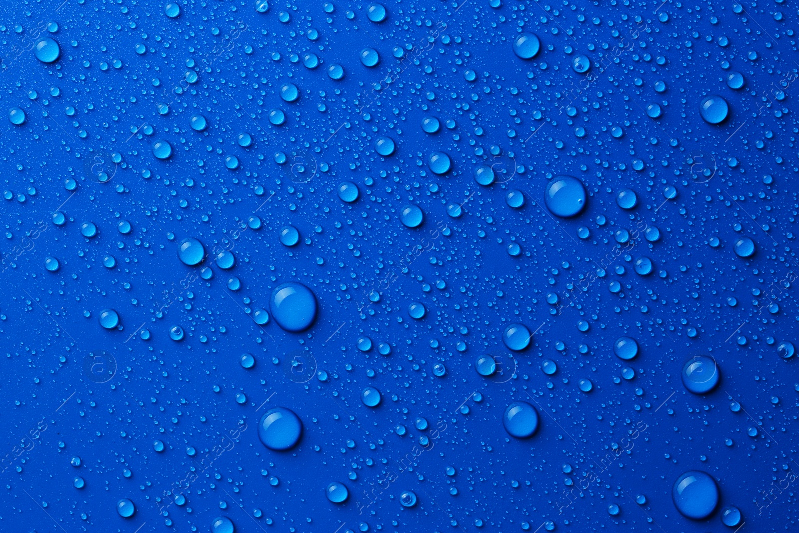 Photo of Water drops on blue background, top view