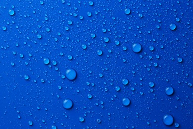 Photo of Water drops on blue background, top view