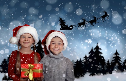 Image of Cute little children and Santa Claus flying in his sleigh against moon sky on background. Christmas celebration