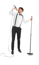 Handsome man in formal clothes singing with microphone on white background