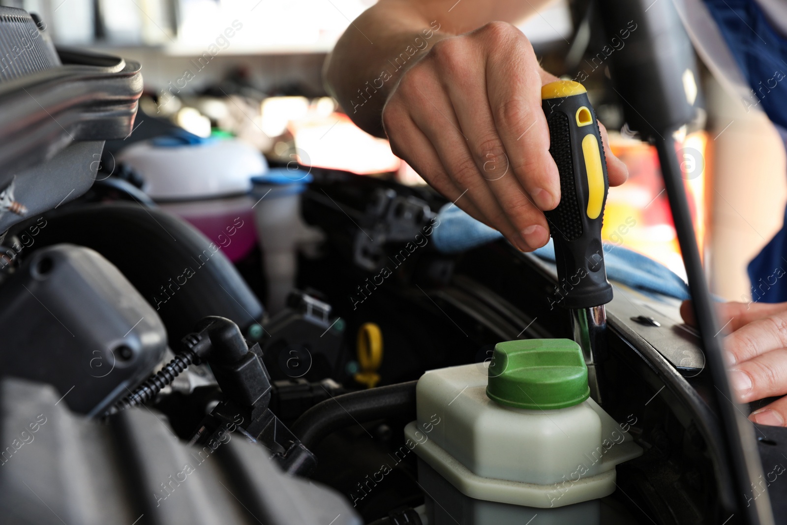 Photo of Professional auto mechanic fixing modern car in service center, closeup