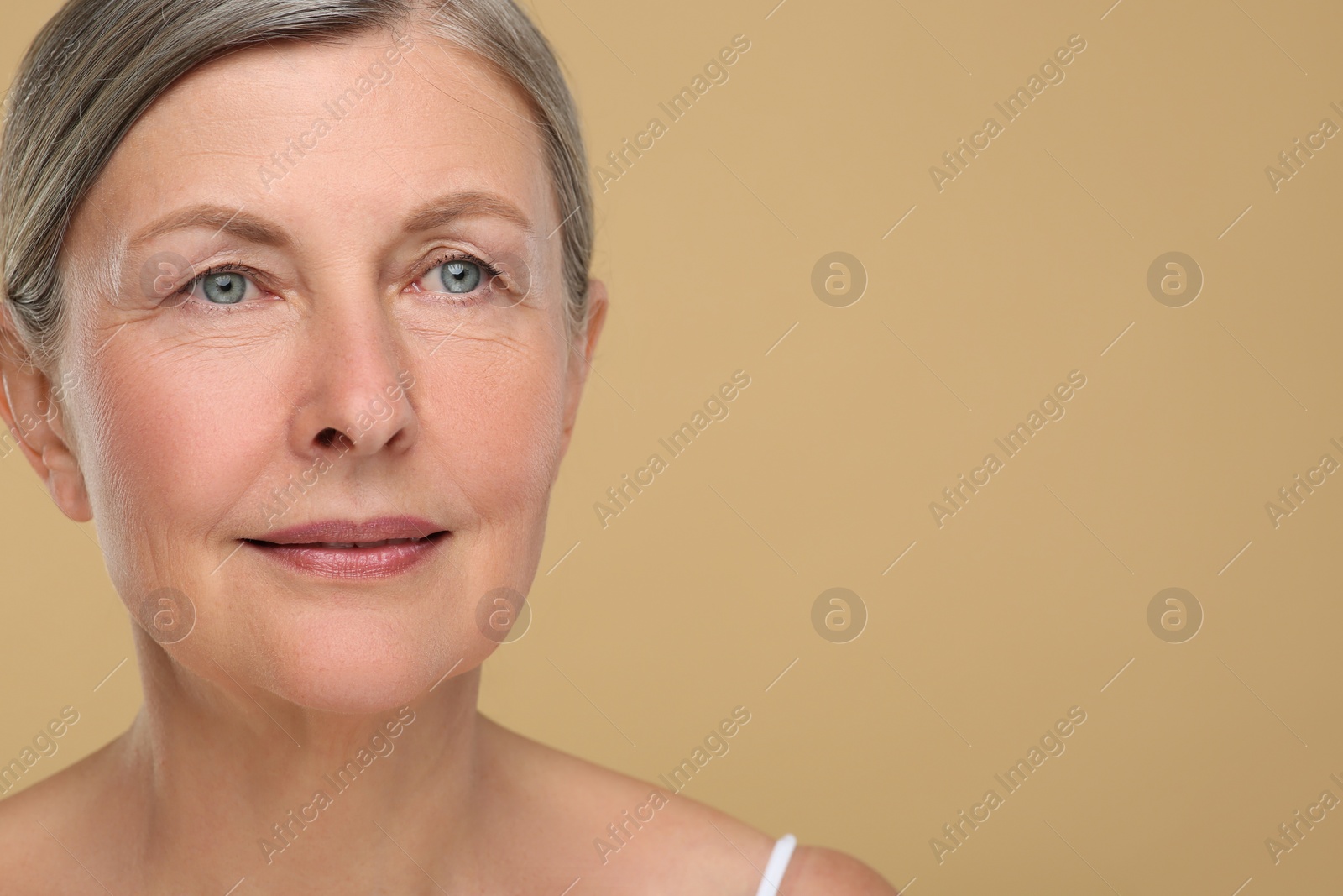 Photo of Portrait of senior woman with aging skin on beige background, space for text. Rejuvenation treatment